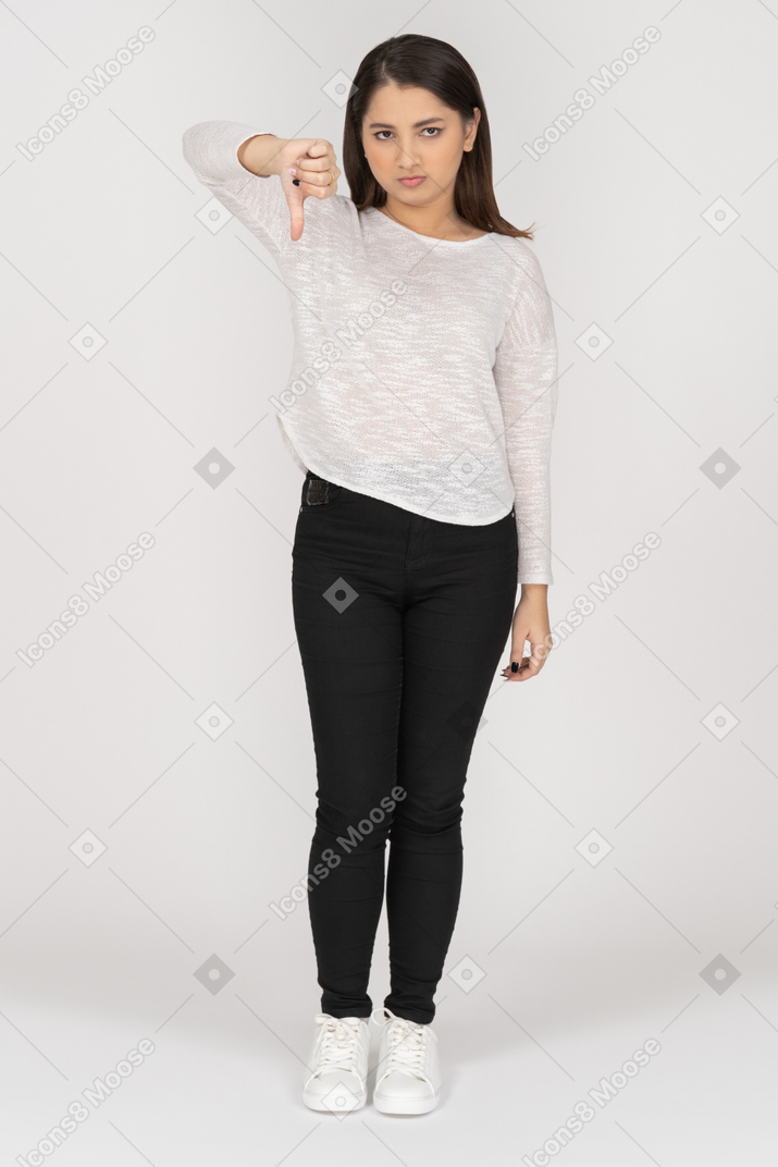 Front view of a young indian female in casual clothing showing thumb down
