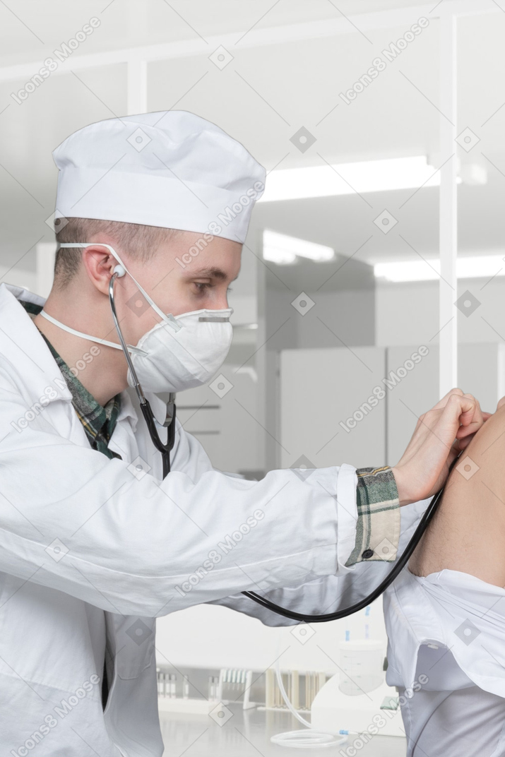 A doctor examining a woman's stomach with a stethoscope