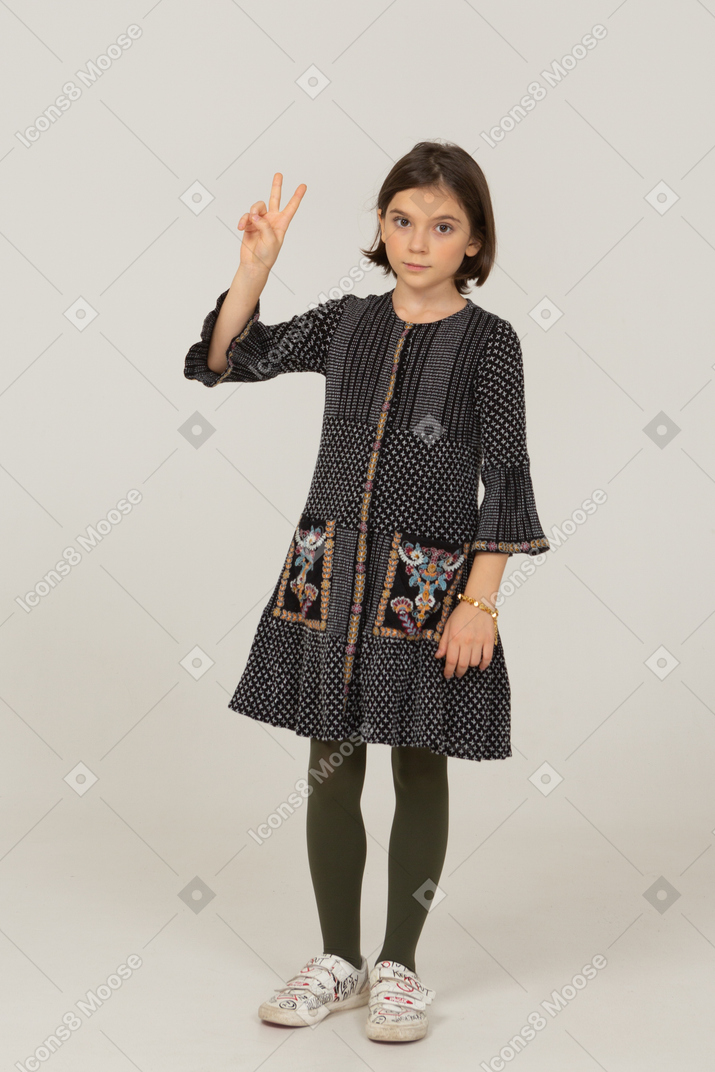 평화 기호를 보여주는 드레스에 어린 소녀의 전면보기
