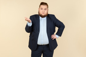 Young overweight man in suit trying to figure out something