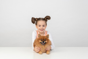 Niña niño sosteniendo un spitz