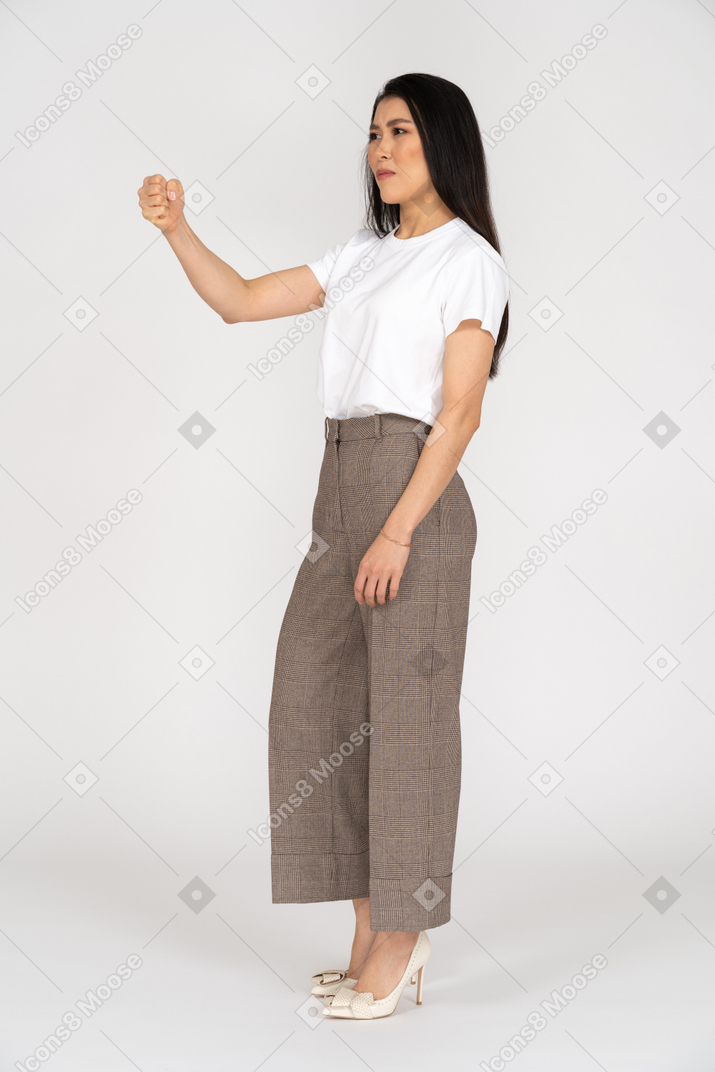 Three-quarter view of a young woman in breeches clenching fist