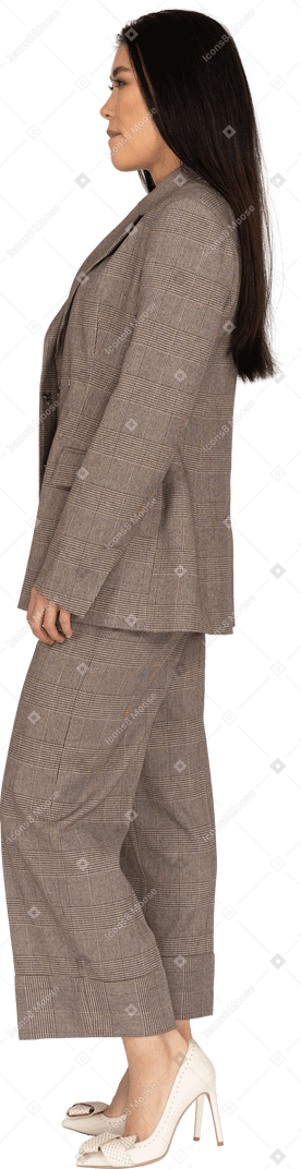 Side view of a young lady in brown business suit biting lips