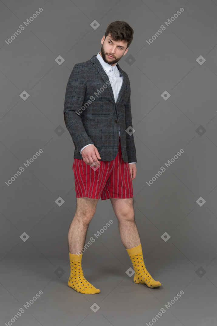 Hombre en shorts rojos mirando a un lado sospechosamente