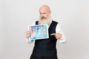 Aged man holding ipad and pointing on it