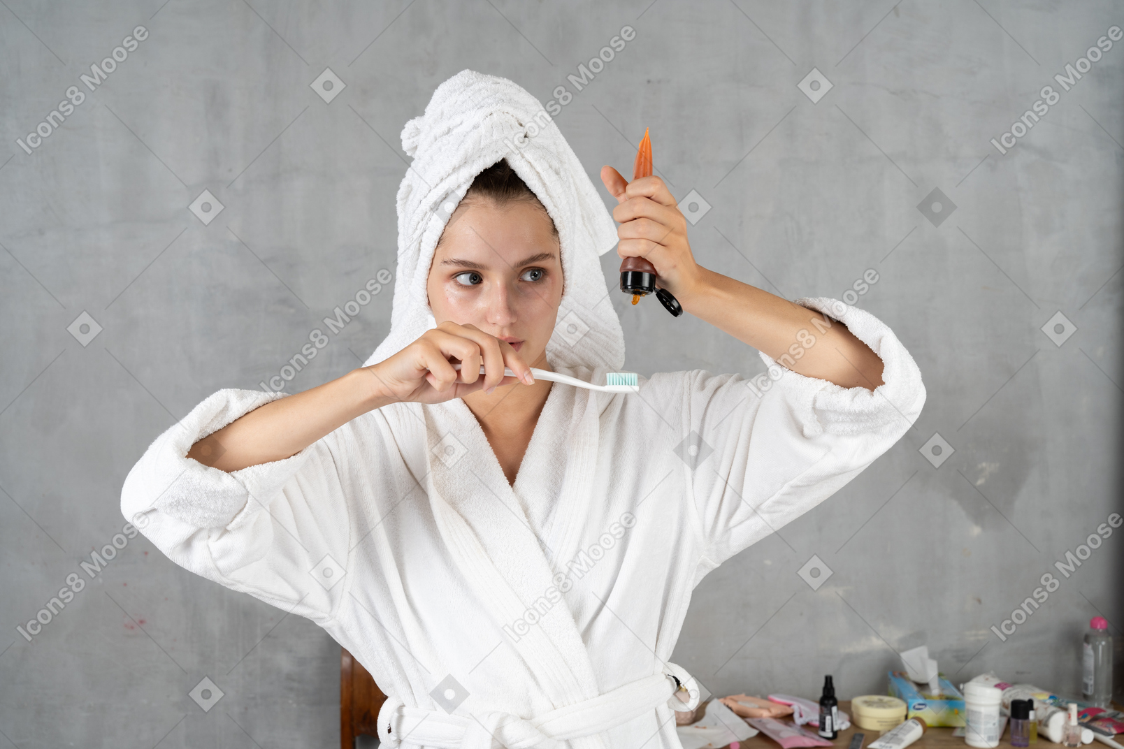 Mulher de roupão de banho espremendo pasta de dente do tubo