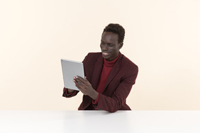 Elegante homem negro sentado à mesa no escritório