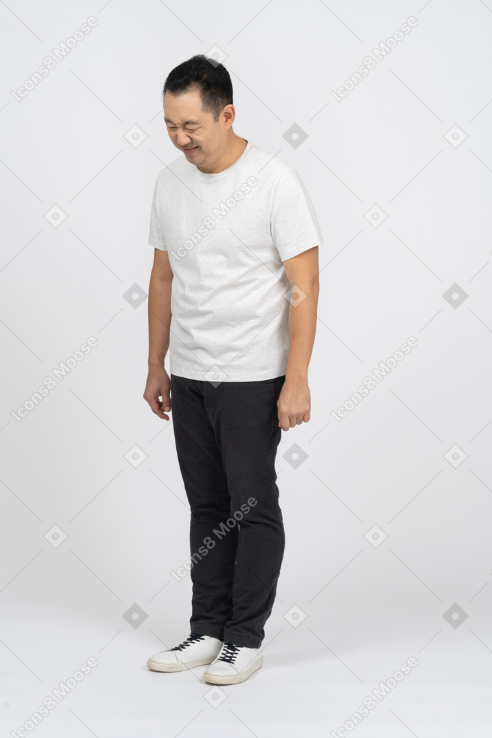 Three-quarter view of a man in casual clothes making funny face