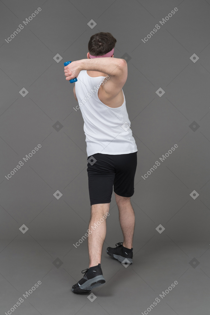 Man exercising with dumbbells back to camera