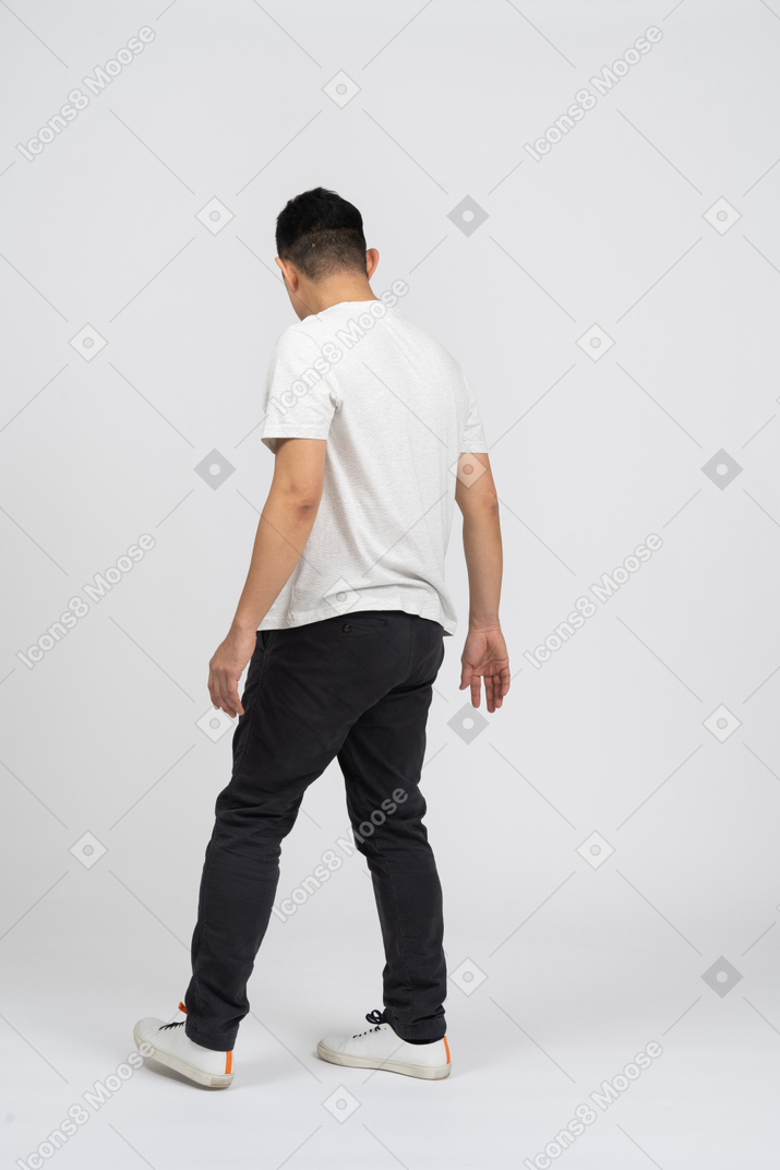 Vista traseira de um homem em roupas casuais, olhando para baixo