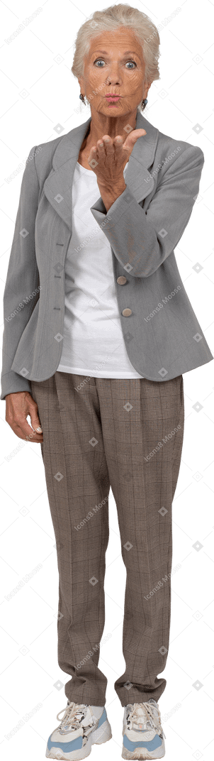 Front view of an old lady in suit blowing a kiss