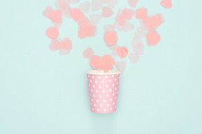 Confetti scattered from polka dot pink paper cup