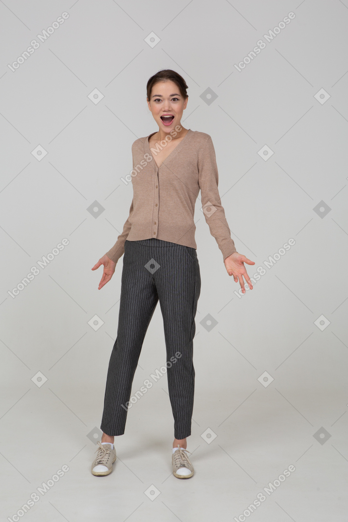 高兴的年轻女子，穿着米色套衫张开她的手的前视图