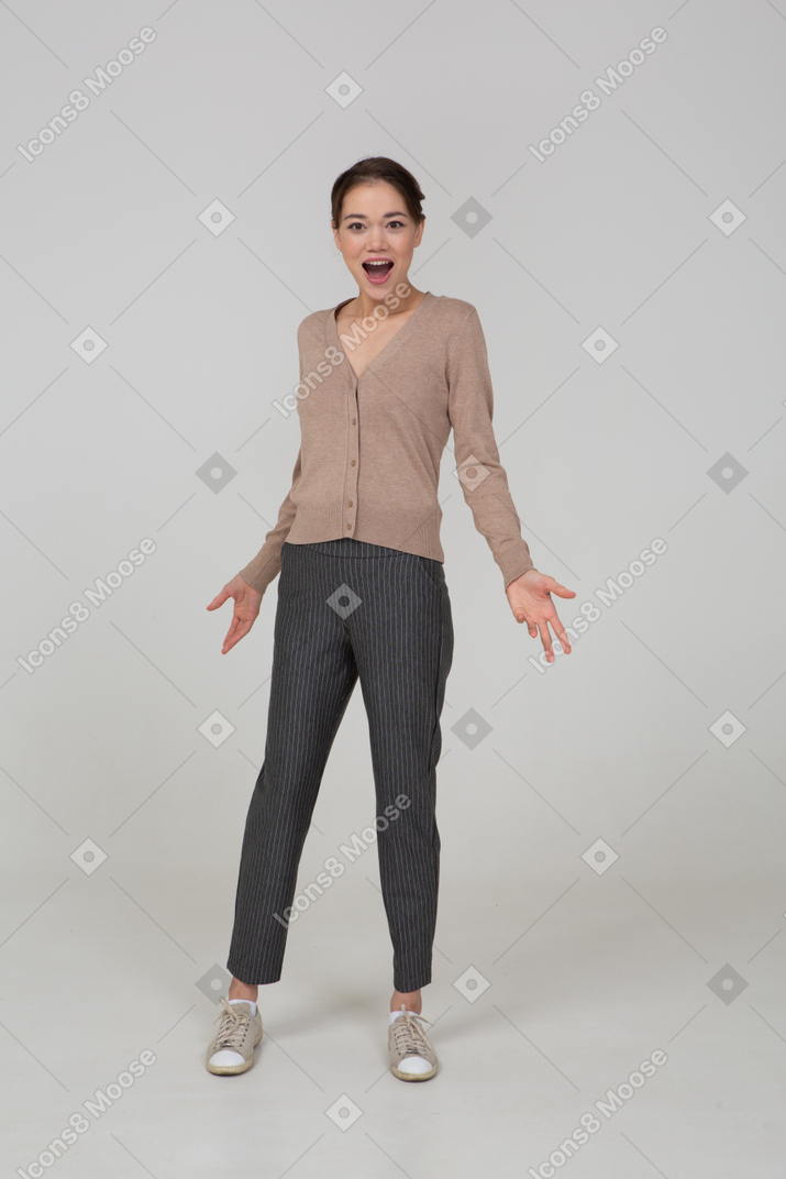 Front view of a pleased young lady in beige pullover outspreading her hands