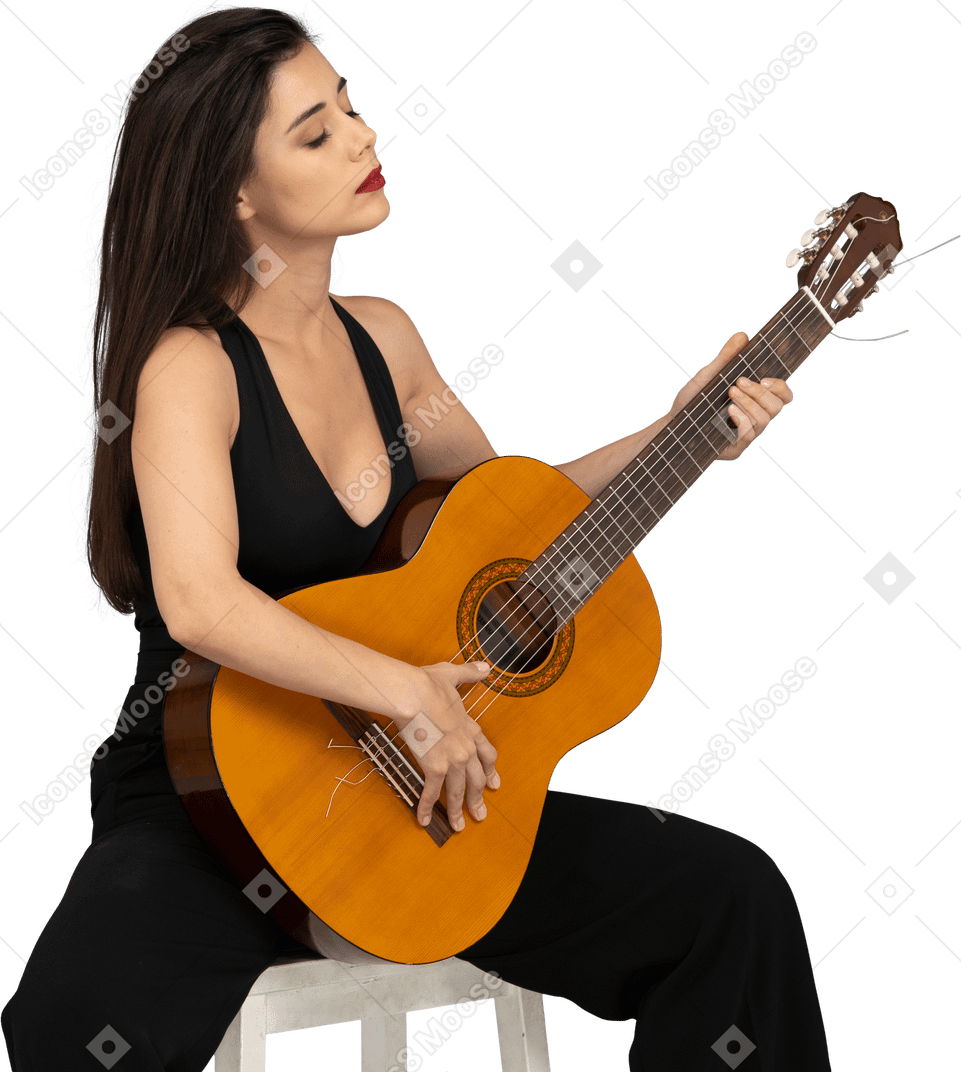坐着的年轻女子，穿着黑色西装，抱着吉他，闭着眼睛的四分之三的视图