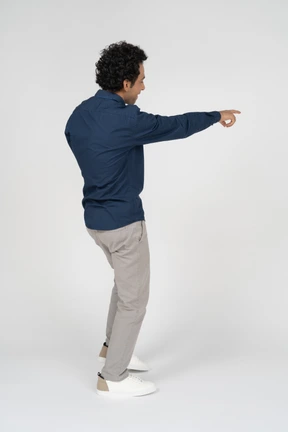Side view of a man in casual clothes pointing with a finger