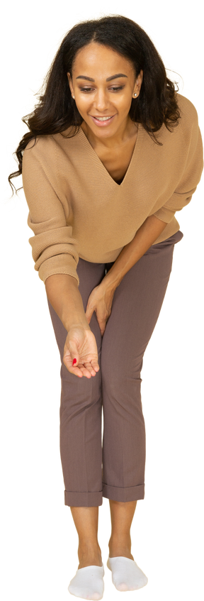 Vista frontal de una mujer joven de piel oscura inclinándose y extendiendo la mano