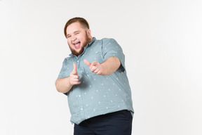 Laughing young overweight man pointing forward