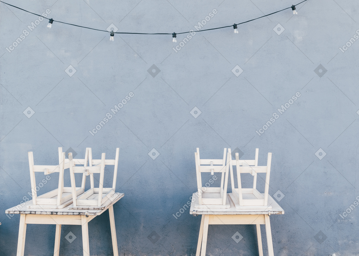 White chairs on white tables in blue room