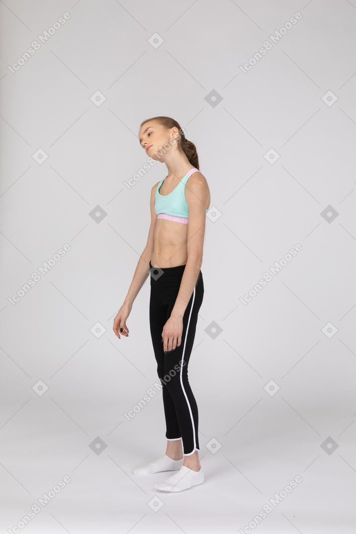 Three-quarter view of a tired teen girl in sportswear tilting her head and rolling eyes