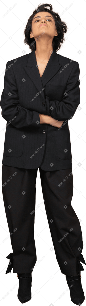 Vista frontal de una empresaria vestida con traje negro cruzando las manos y echando la cabeza hacia atrás