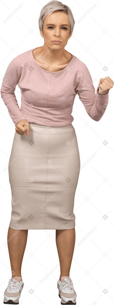 Вид спереди сердитой женщины в повседневной одежде, показывающей кулак