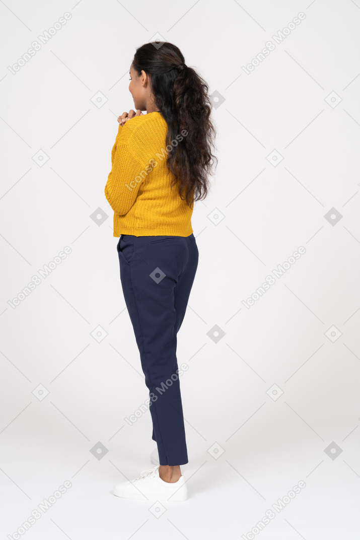 Rear view of a girl in casual clothes making praying gesture
