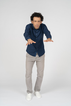 Front view of a man in casual clothes standing with outstretched arms
