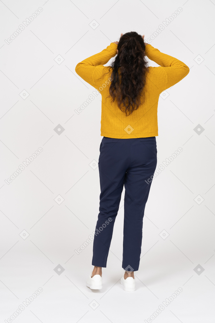 指で角を作るカジュアルな服装の女の子の背面図