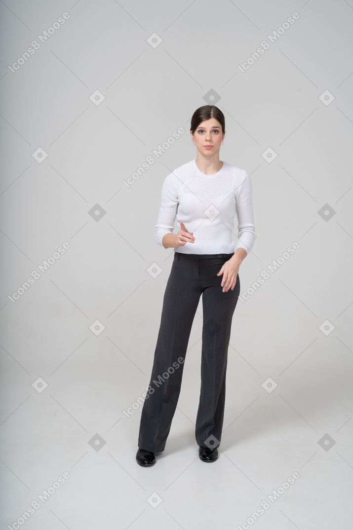 指で指しているスーツを着た若い女性の正面図