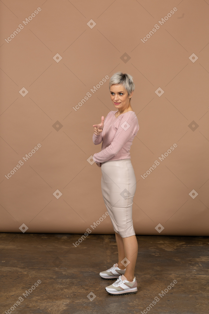Vista laterale di una donna in abiti casual che indica con il dito