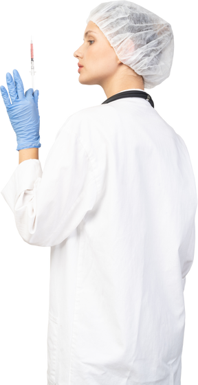 Vista posterior de tres cuartos de una joven doctora sosteniendo una jeringa
