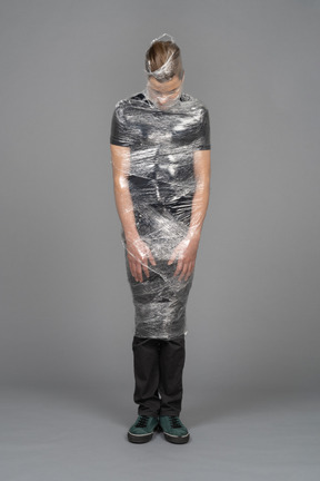 Front view of a young man wrapped in plastic