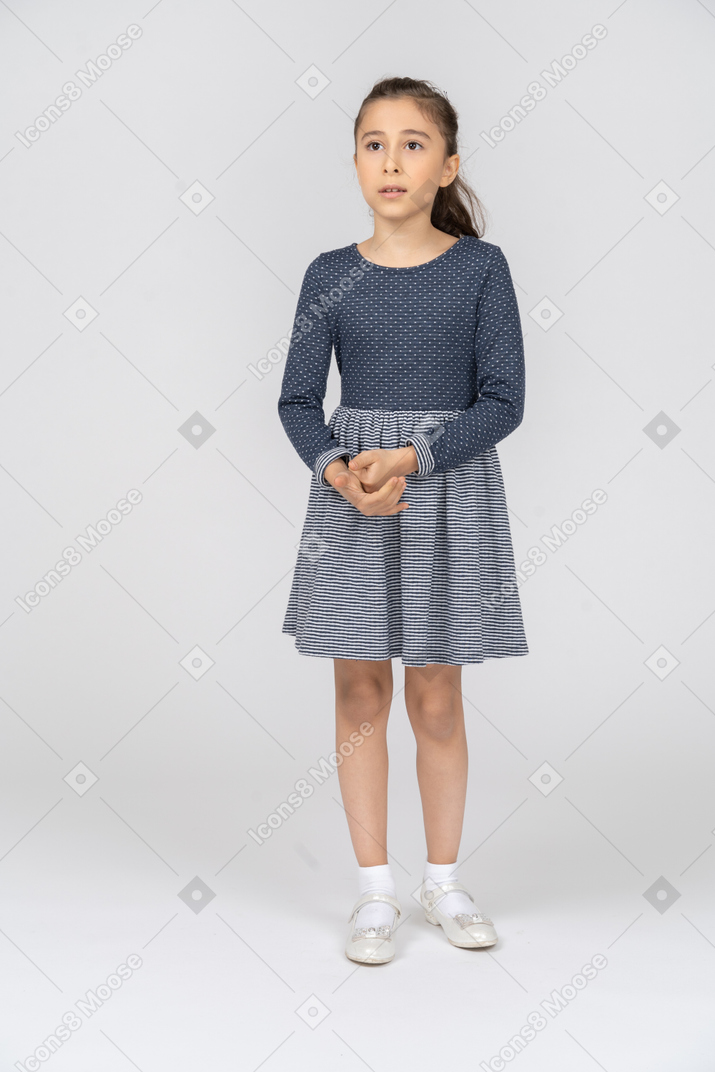 Front view of a girl clasping hands uncertainly