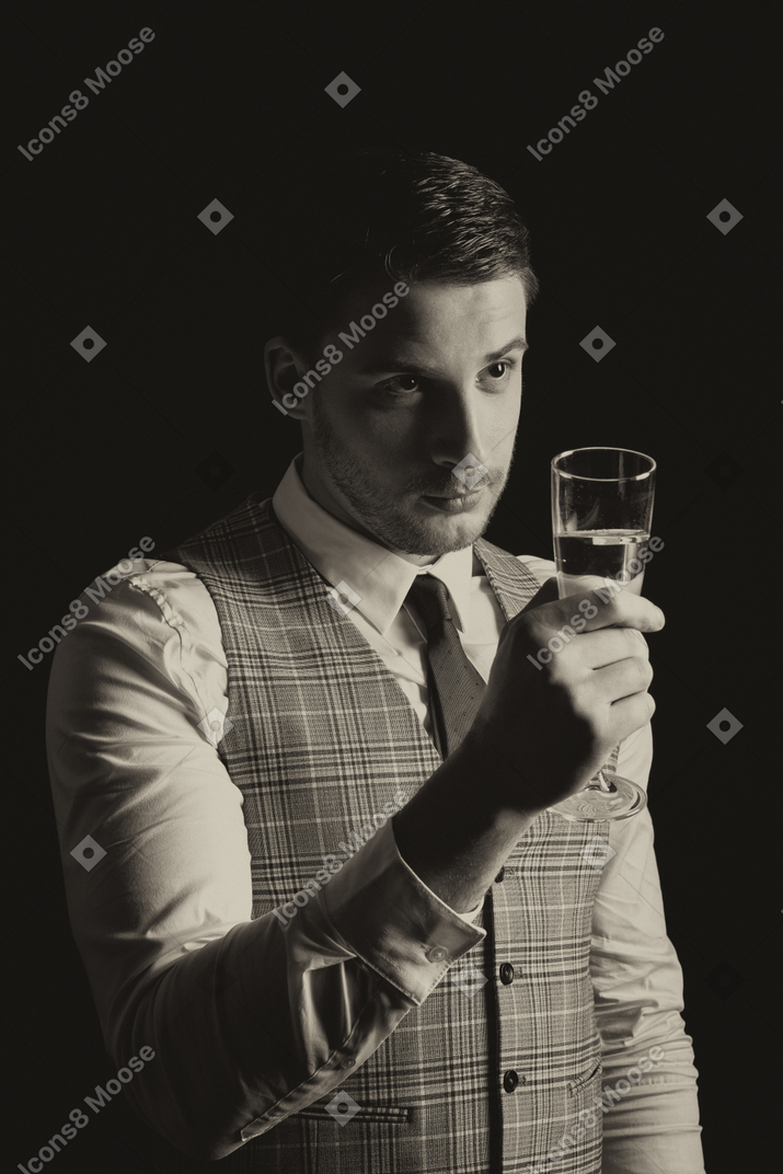 Jovem e atraente cavalheiro erguendo uma taça de champanhe