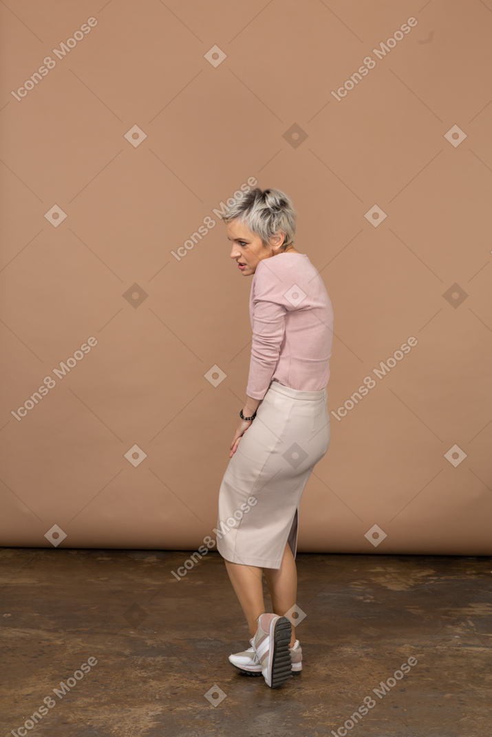 Side view of an emotional woman in casual clothes suffering from pain