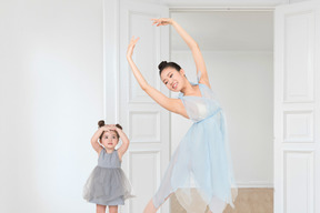 A woman and a little girl dancing in a room