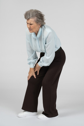 Old woman touching her sore knee