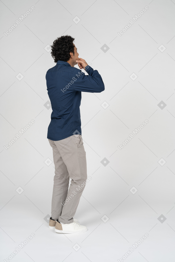 Side view of a man in casual clothes touching his mouth