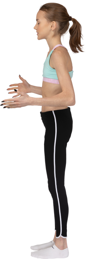 Vista lateral posterior de una jovencita en ropa deportiva levantando las manos y discutiendo
