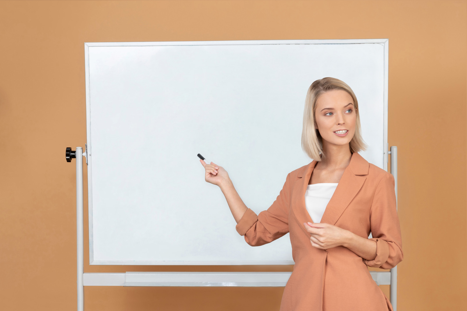 Attractive woman standing next to a whiteboard and explaining something