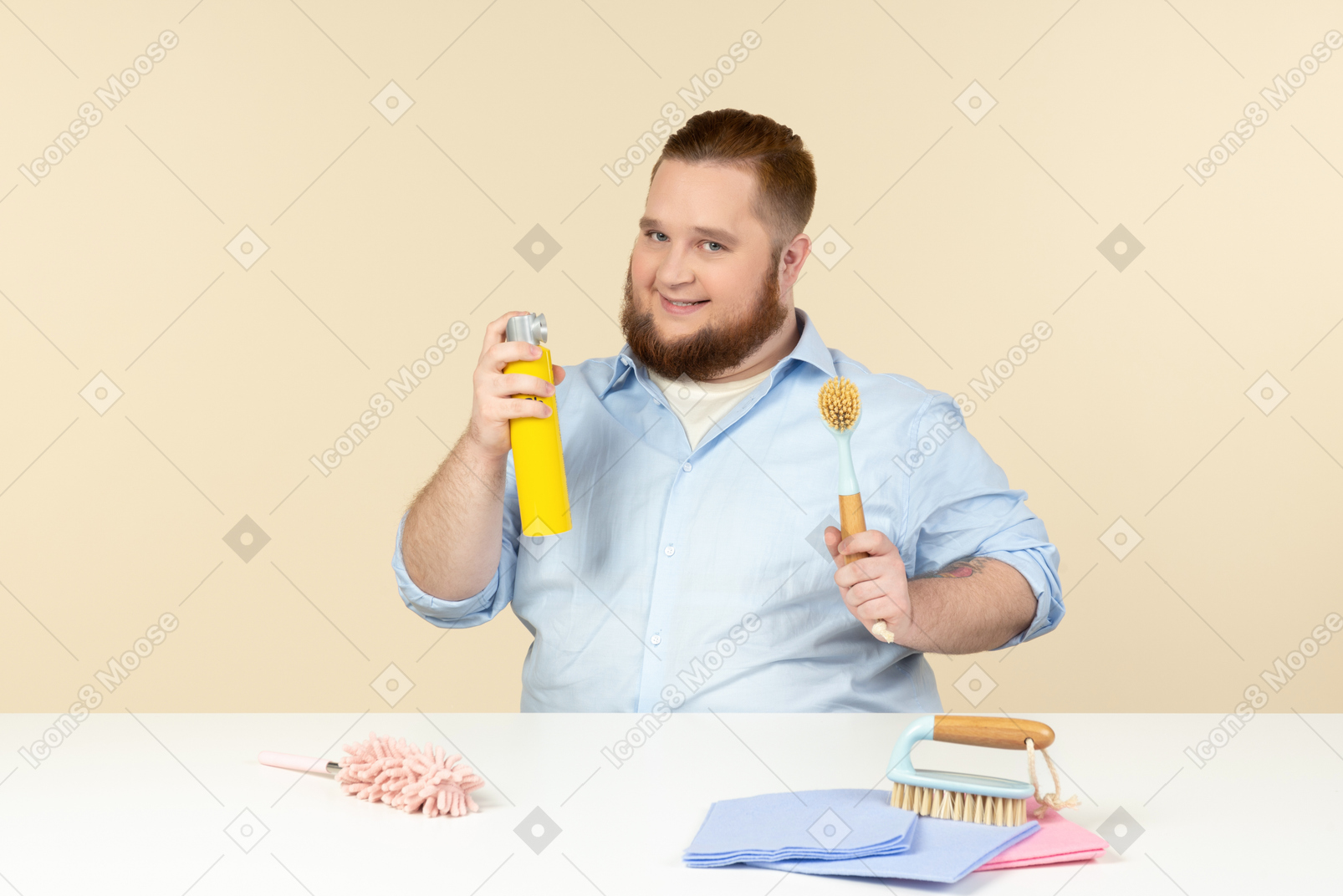 Riendo househusband joven con sobrepeso con spray de limpieza y trapos