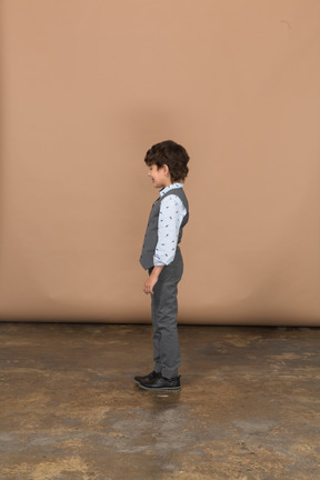 Cute boy in suit standing in profile