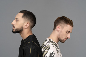 Close-up of a caucasian male couple standing back to back