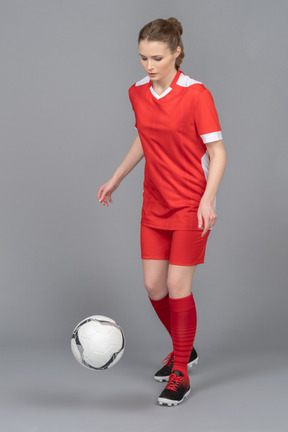 A female football player driving a ball