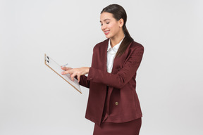 Attractive formally dressed woman checking notes