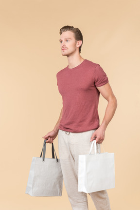 Young guy holding white shopping bags