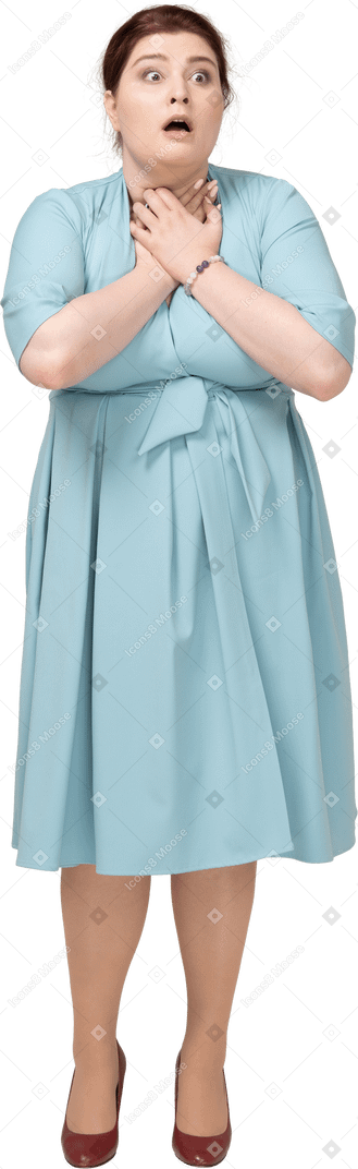 Vista frontale di una donna scioccata in abito blu che le tocca il collo