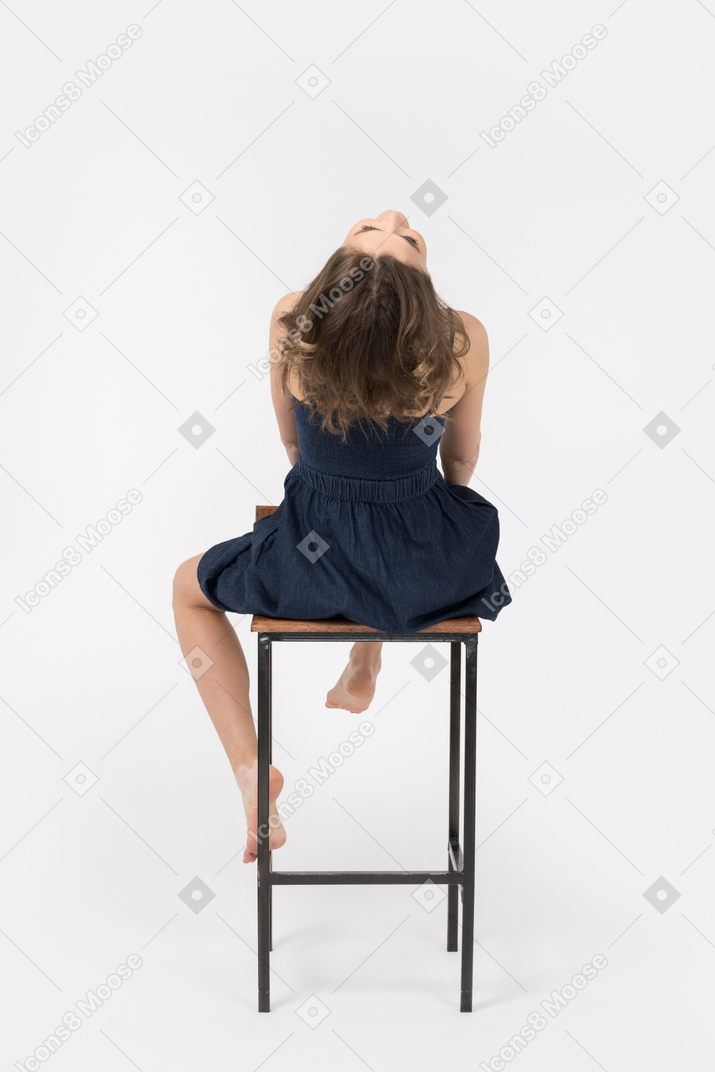 Sensual girl reclining while sitting on bar stool