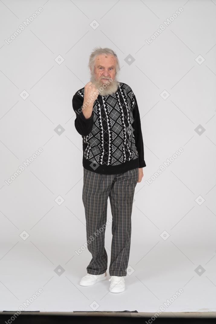 Old man looking at camera and threatening with fist
